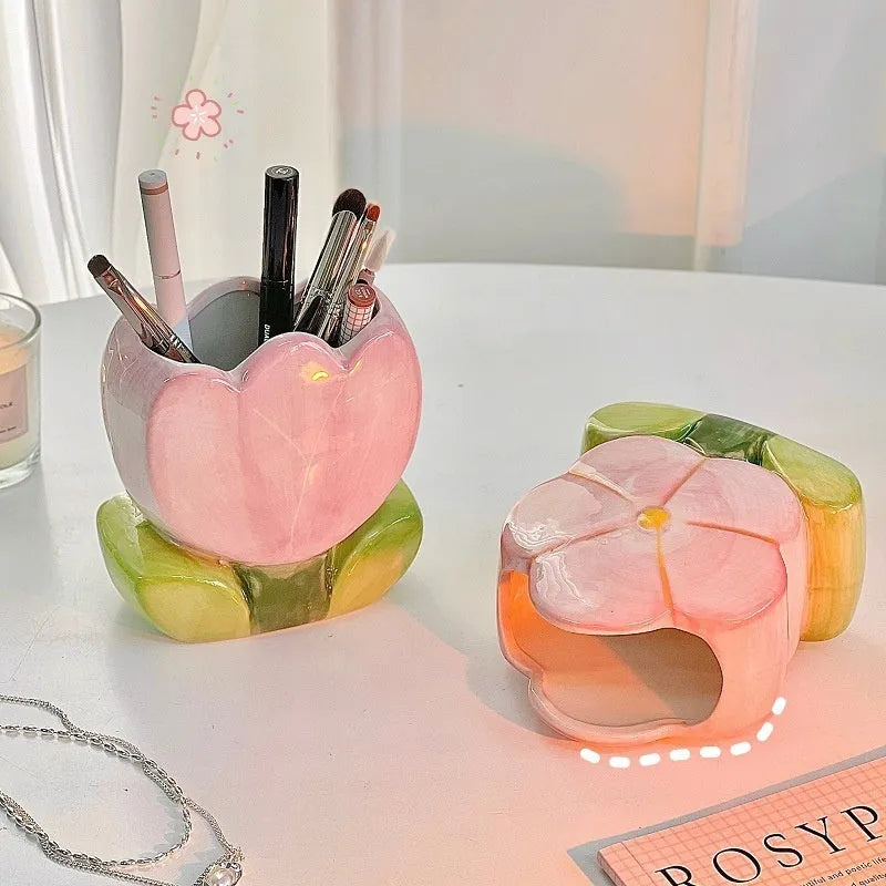 Ceramic pen holder storage box with floral decoration on desk.