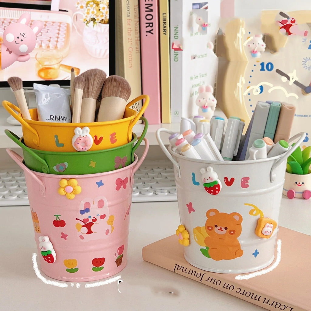 Round metal desk pen holder in a choice of colours, some with decorative sticker patches, for student stationery organisation.