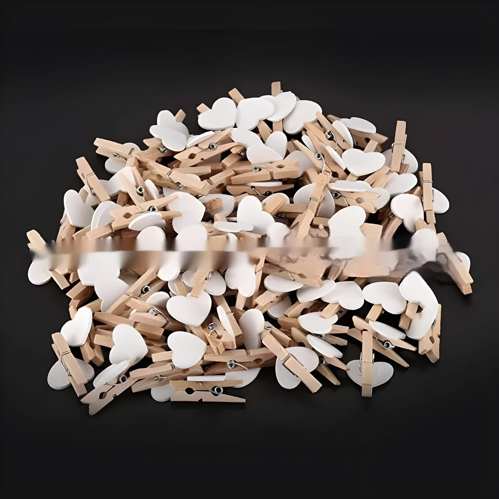 Set of five handmade solid wood heart-shaped clips in red, pink, white, and yellow on a wooden surface.