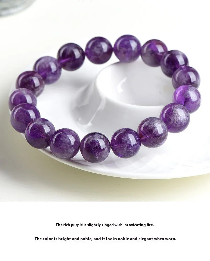 Snow Mountain feather amethyst crystal bracelet with geometric beads and Ruyi elements on a wrist.