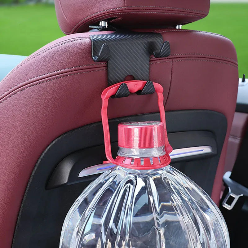 Black ABS car storage hook with carbon fibre pattern, combining a bag hook and mobile phone holder for rear seat installation.