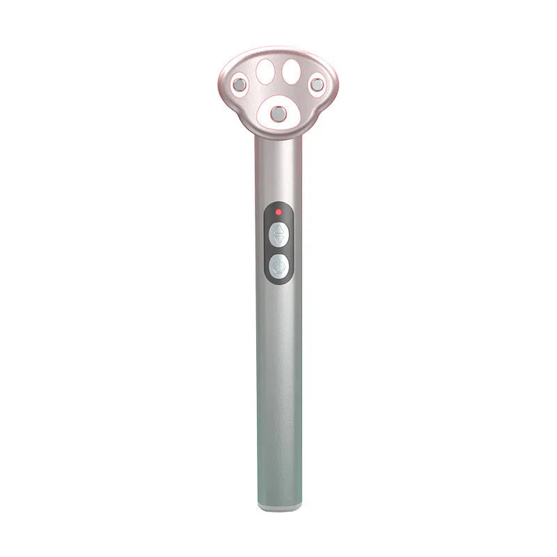 Gradient pink Cat's Paw micro-current eye massager with charging cable.