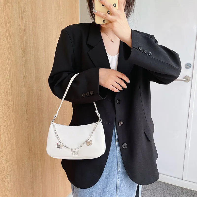 Butterfly chain underarm bag in black PU leather with crossbody strap and internal organisation pockets
