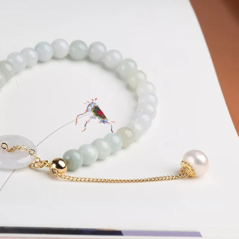 Green jade peace buckle charm and pearl beaded bracelet for women on a white background.