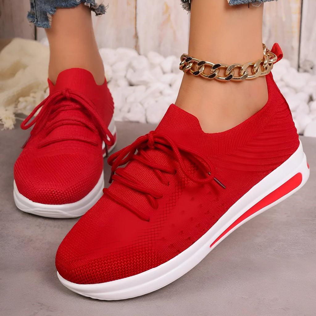 Women's red, black, and blue low-top casual sneakers with a round toe and lace-up front.