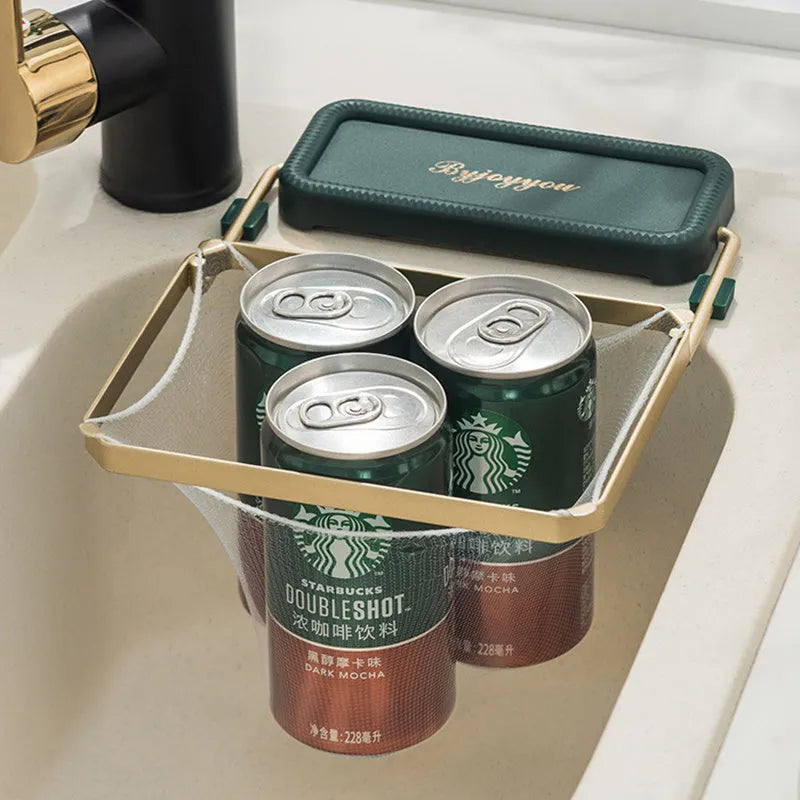Foldable sink filter rack in dark green gold with disposable mesh bag on a stainless steel sink