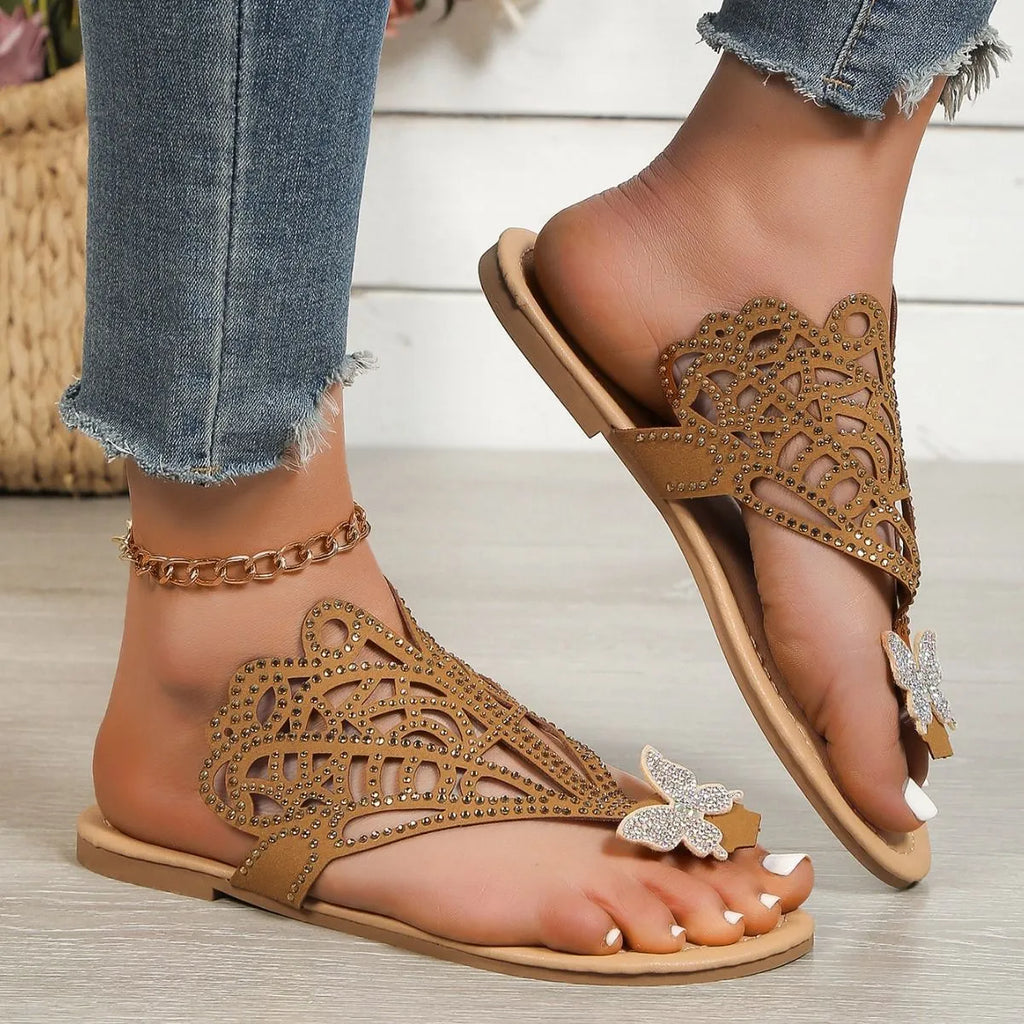 Gold women's flip-toe sandals with hollow-out design and rhinestone decorations on a flat rubber sole.