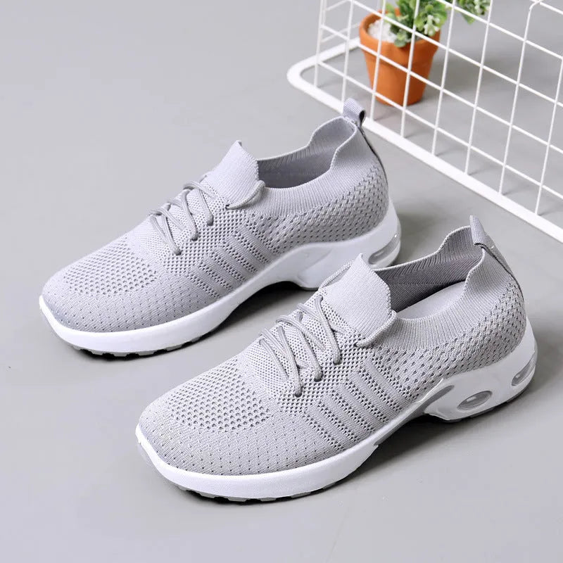 Women's solid colour casual sneaker with mesh upper, round toe, and front laces.
