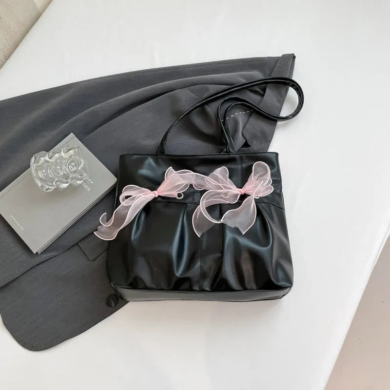 College style black bow tote bag with double shoulder straps showing interior zippered pocket