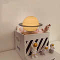 Maglev floating moon planet night light with LED glow and astronaut figures on a table
