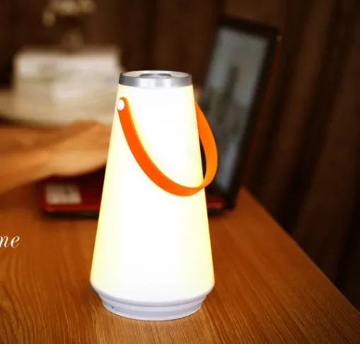 White rechargeable LED lantern night light with USB cable on a table
