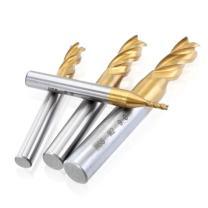 Set of 7 high speed steel 4-flute end mills with round shank on a metal workbench