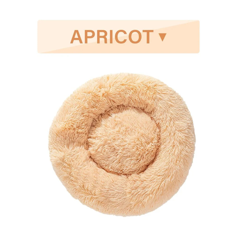 Fluffy donut-shaped dog bed in long plush material, shown in a grey colour, with a raised rim.