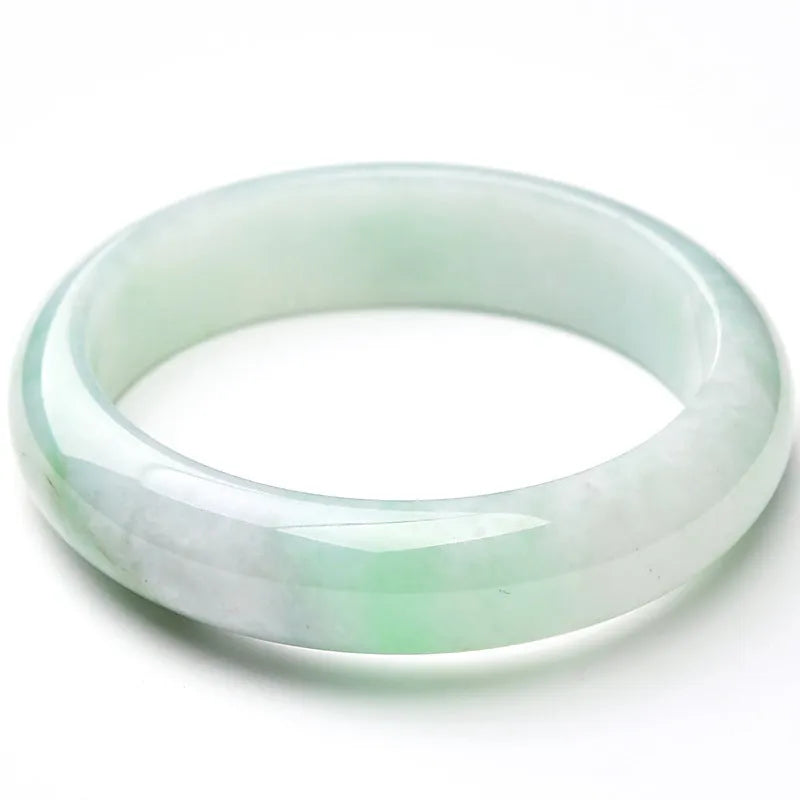 Natural light green jade bracelet on a wrist, showing unisex design and stone detail.
