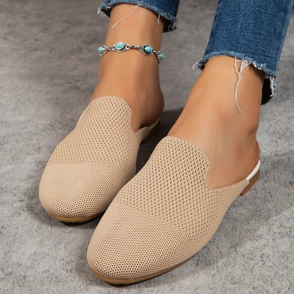 A pair of apricot-coloured mesh slip-on flat sandals with a round toe and rubber sole.