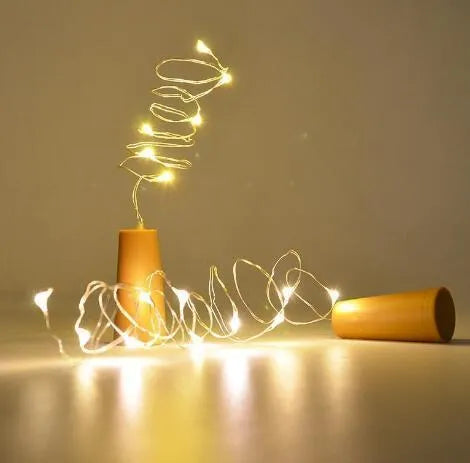 2 metre long copper wire LED light string wrapped around a glass wine bottle with 20 small white LEDs.