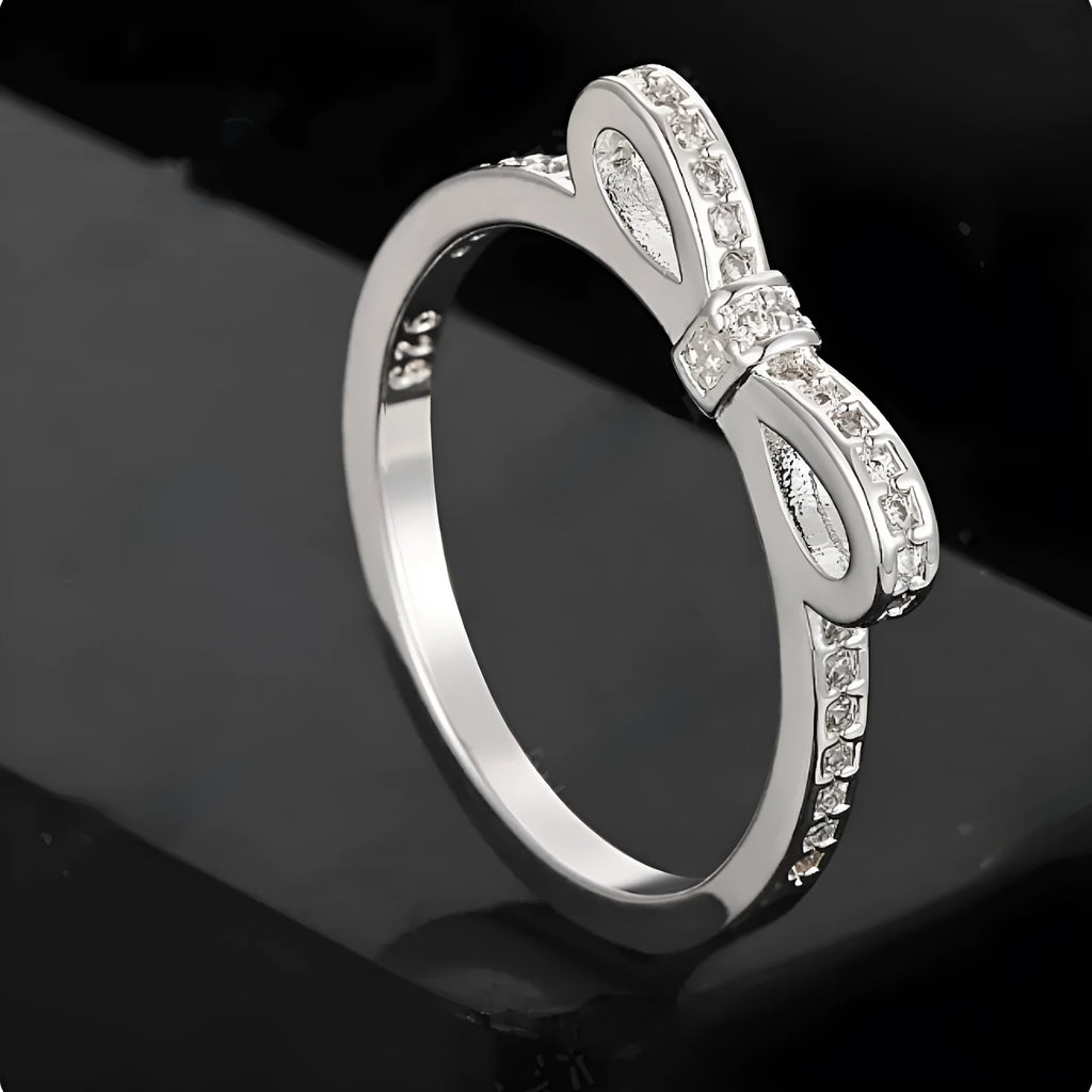 Silver couple style bow ring with rhinestone zircon crystals on finger showing electroplated finish