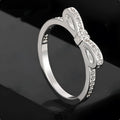 Silver couple style bow ring with rhinestone zircon crystals on finger showing electroplated finish