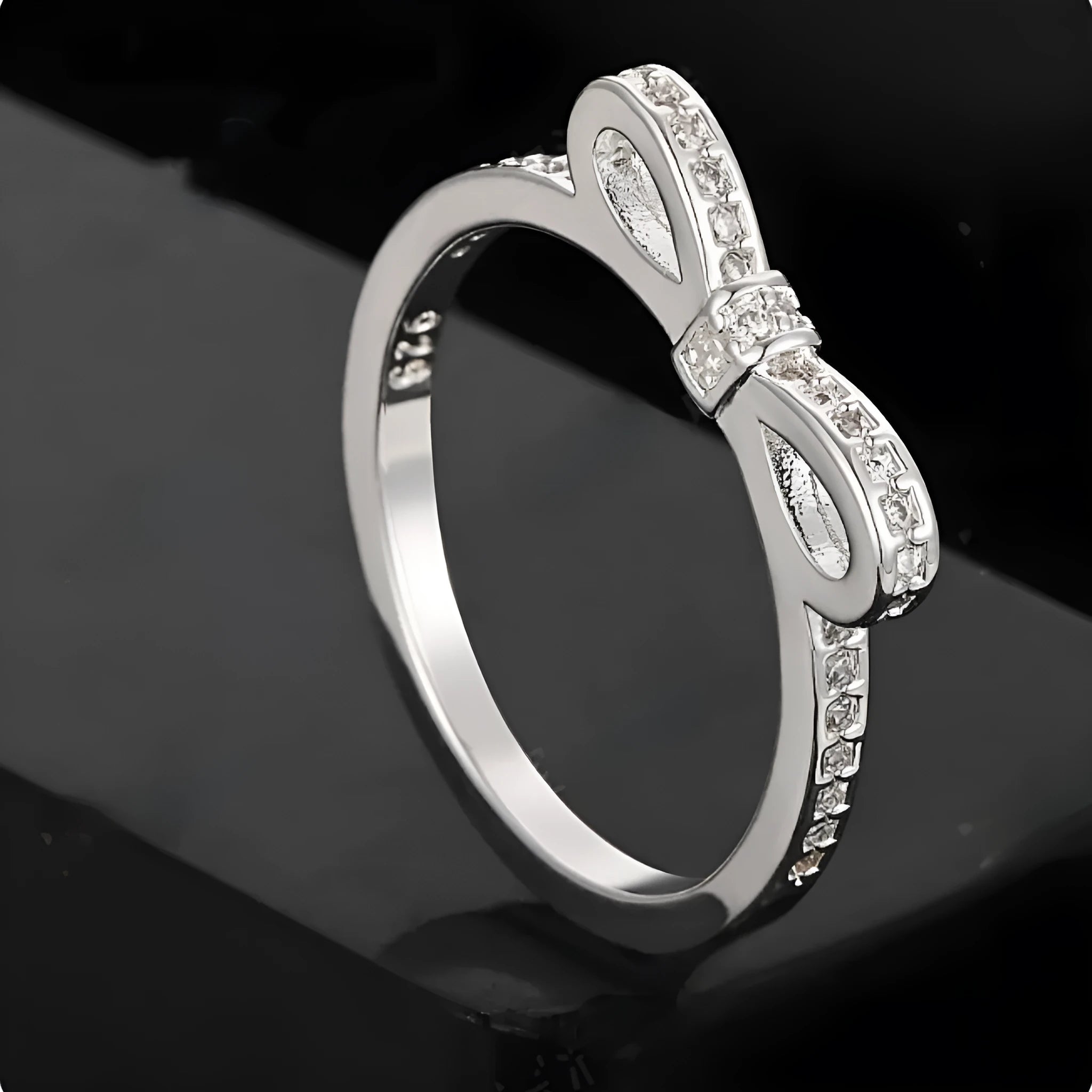 Silver couple style bow ring with rhinestone zircon crystals on finger showing electroplated finish