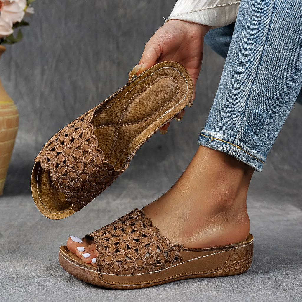 Women's wedge beach slippers with flower cutout design on PVC upper and fish-mouth toe shape.