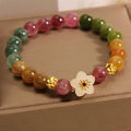 Tourmaline bracelet with floral or fu character design on a white background.