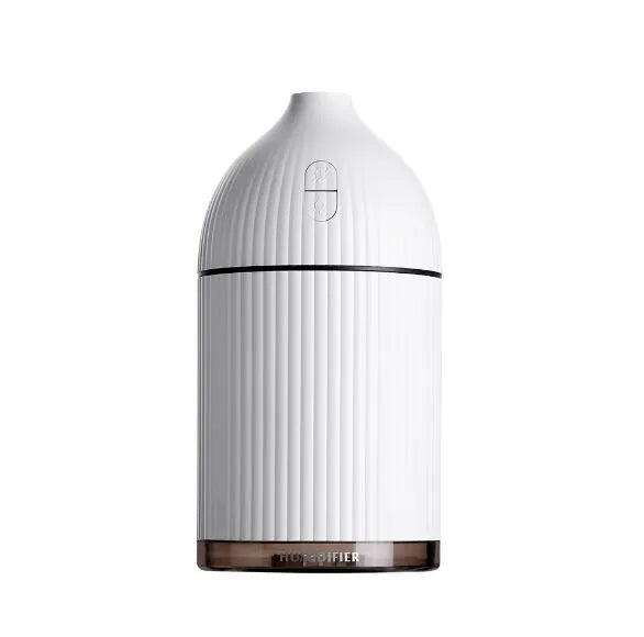 White square aromatherapy diffuser and humidifier with LED light on a wooden desk.