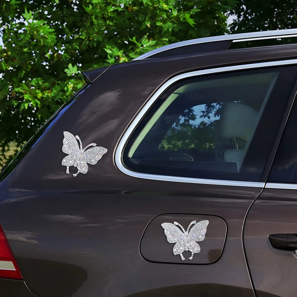 Glass car sticker with diamond detailing in butterfly or bear claw design, 7cm by 6cm.