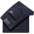 Man wearing loose fit straight-leg stretch jeans in blue denim for a business casual look.