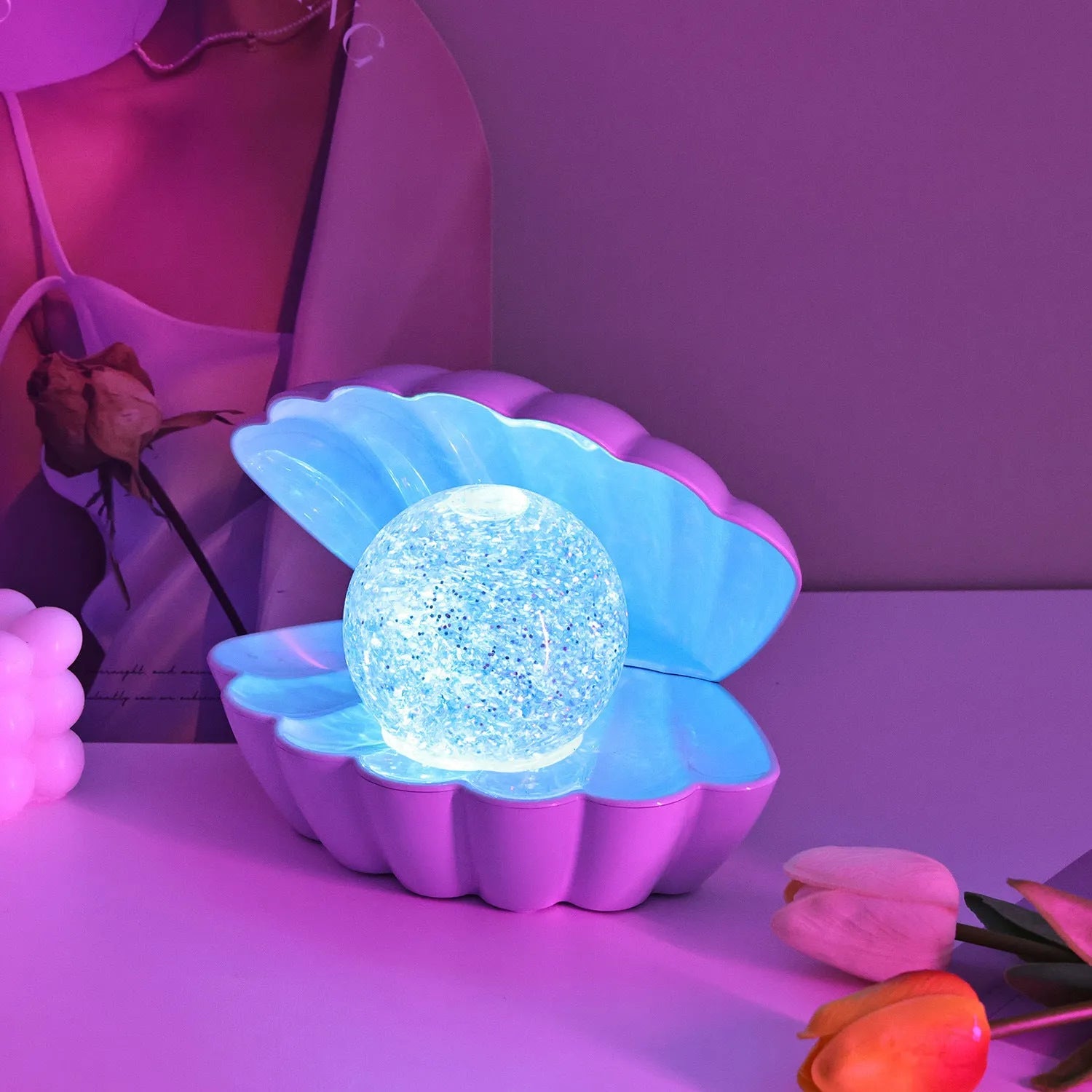 Shell-shaped small night lamp with neon ambience lighting on a table.