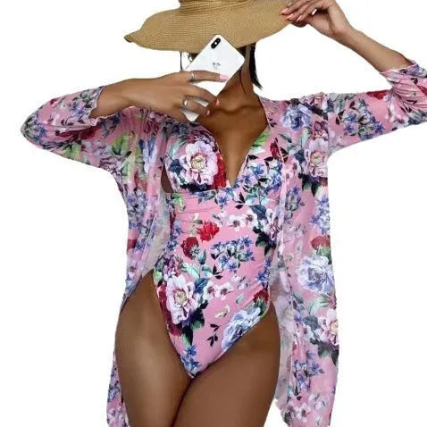 Women's floral print three-piece bikini set with a cover-up coat on a hanger