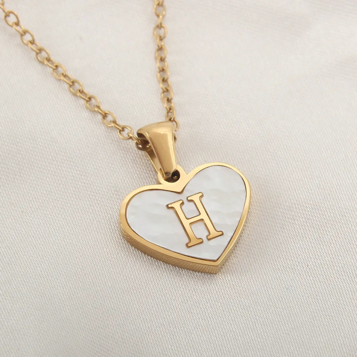 Gold plated heart necklace with white shell detail on an adjustable chain