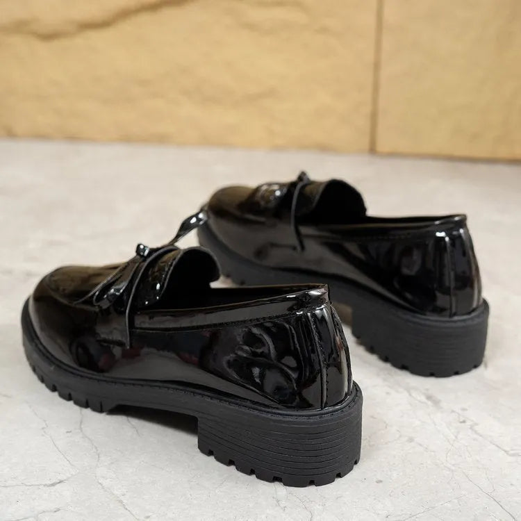 Women's brown and black loafers with a decorative bow on the front.