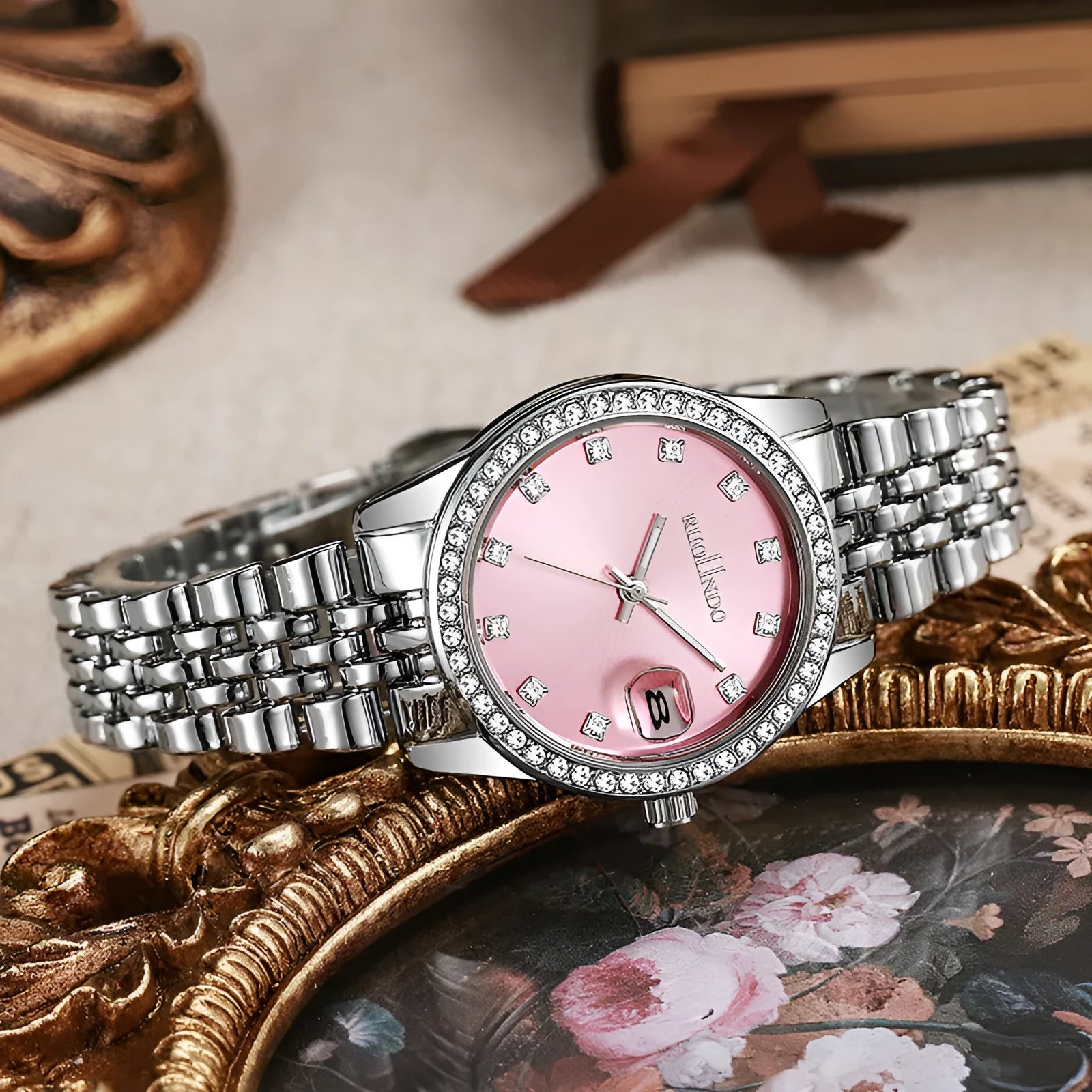 Women's silver alloy calendar watch with circular dial and stainless steel buckle on a wrist.