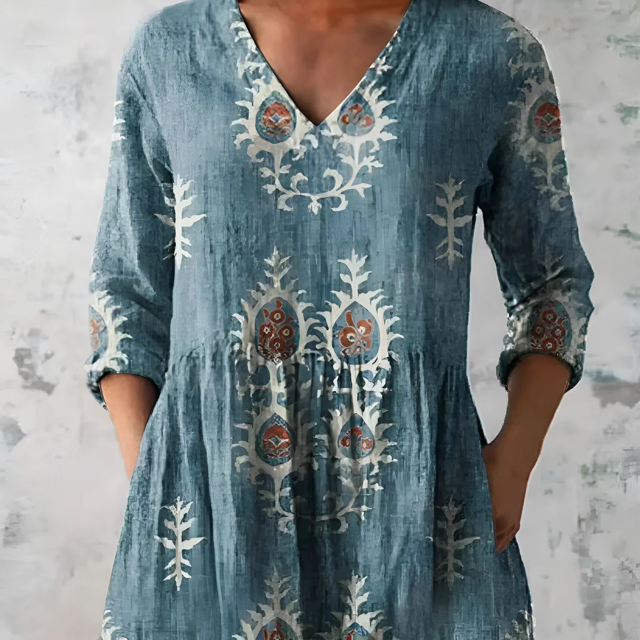 Printed women's loose dress with wide waist and three-quarter length sleeves on a hanger.