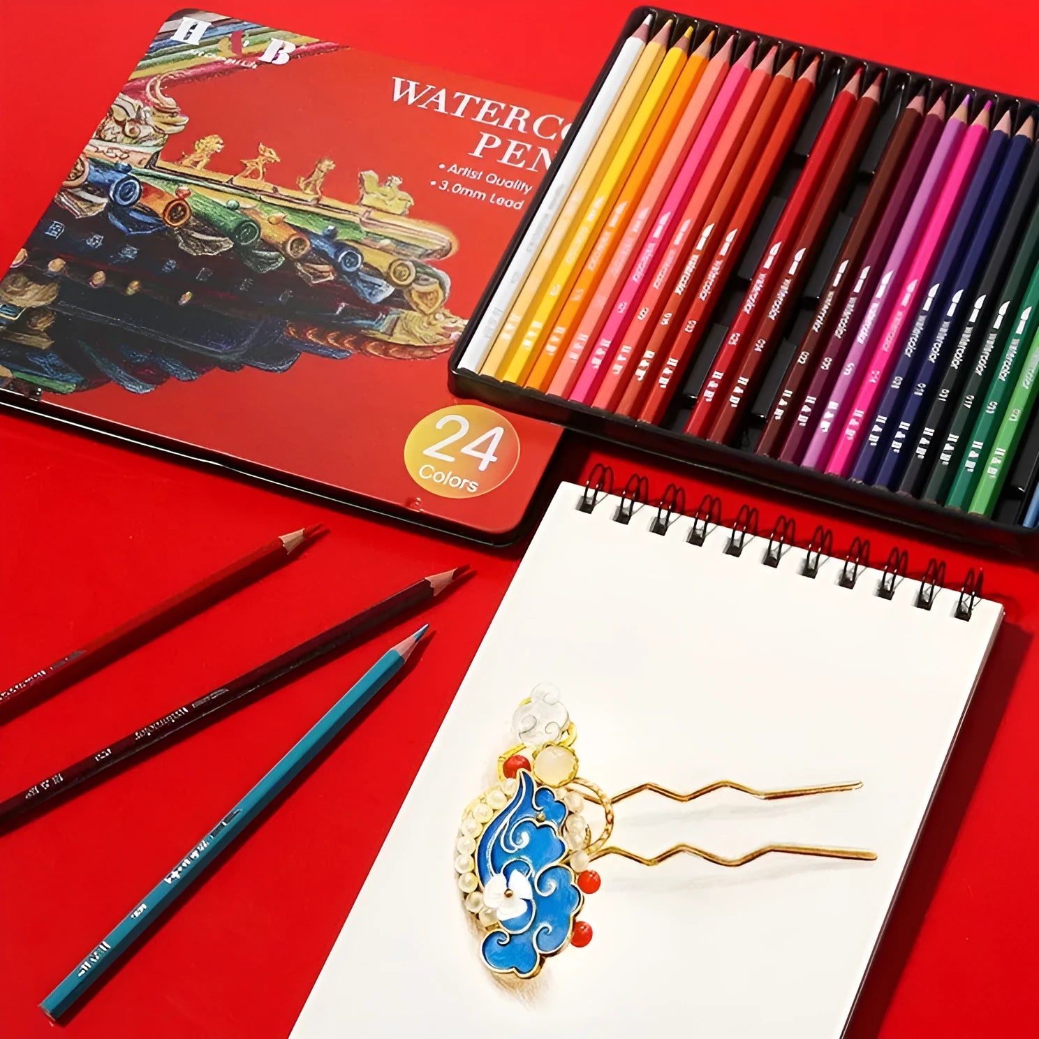 Water-soluble coloured pencil set with 24 colours, a brush, and a metal box open to show contents.