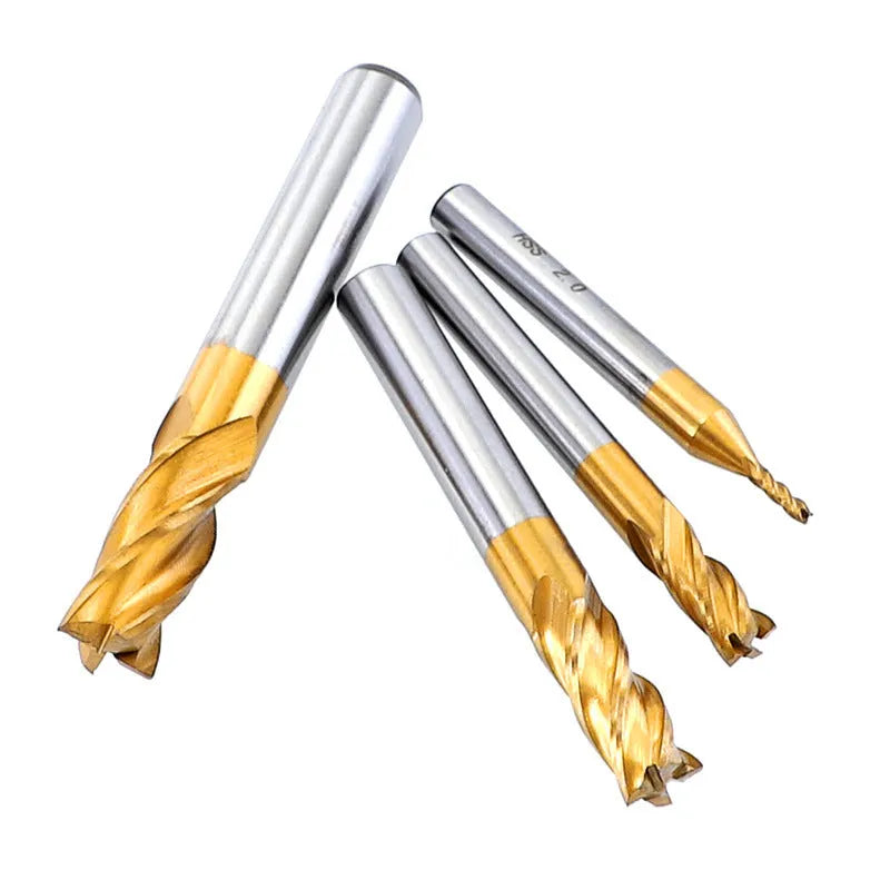 Set of 7 high speed steel 4-flute end mills with round shank on a metal workbench