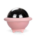 Green UFO-shaped plastic night light projecting starry sky pattern on a wall