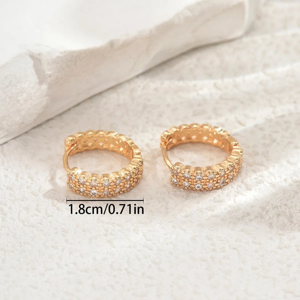 A pair of women's geometric pattern copper ear studs with round, dot, and ring details.