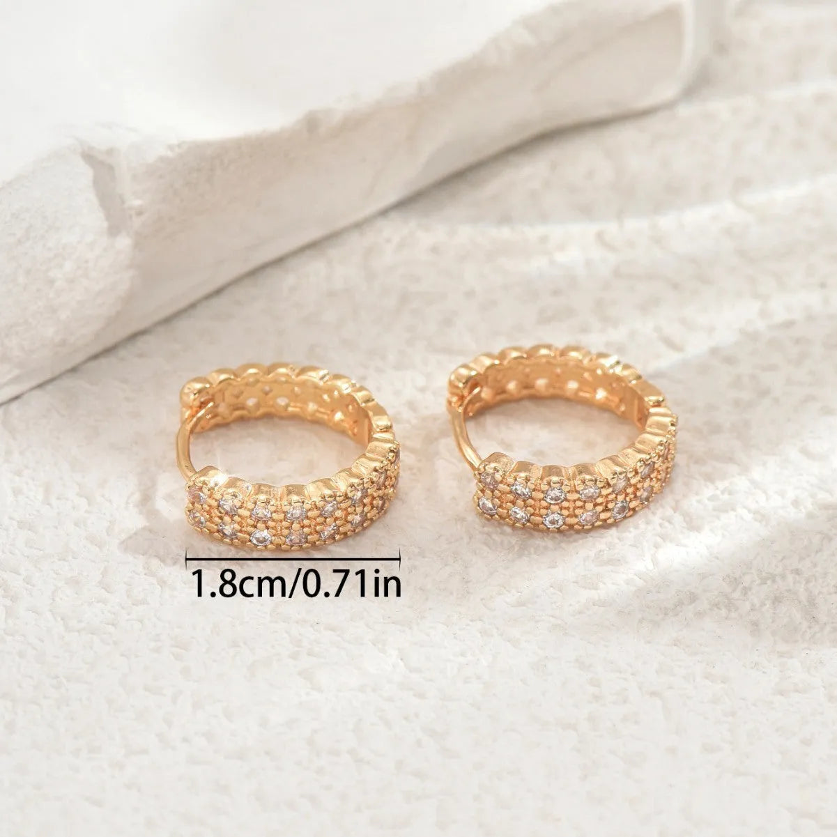 A pair of women's geometric pattern copper ear studs with round, dot, and ring details.