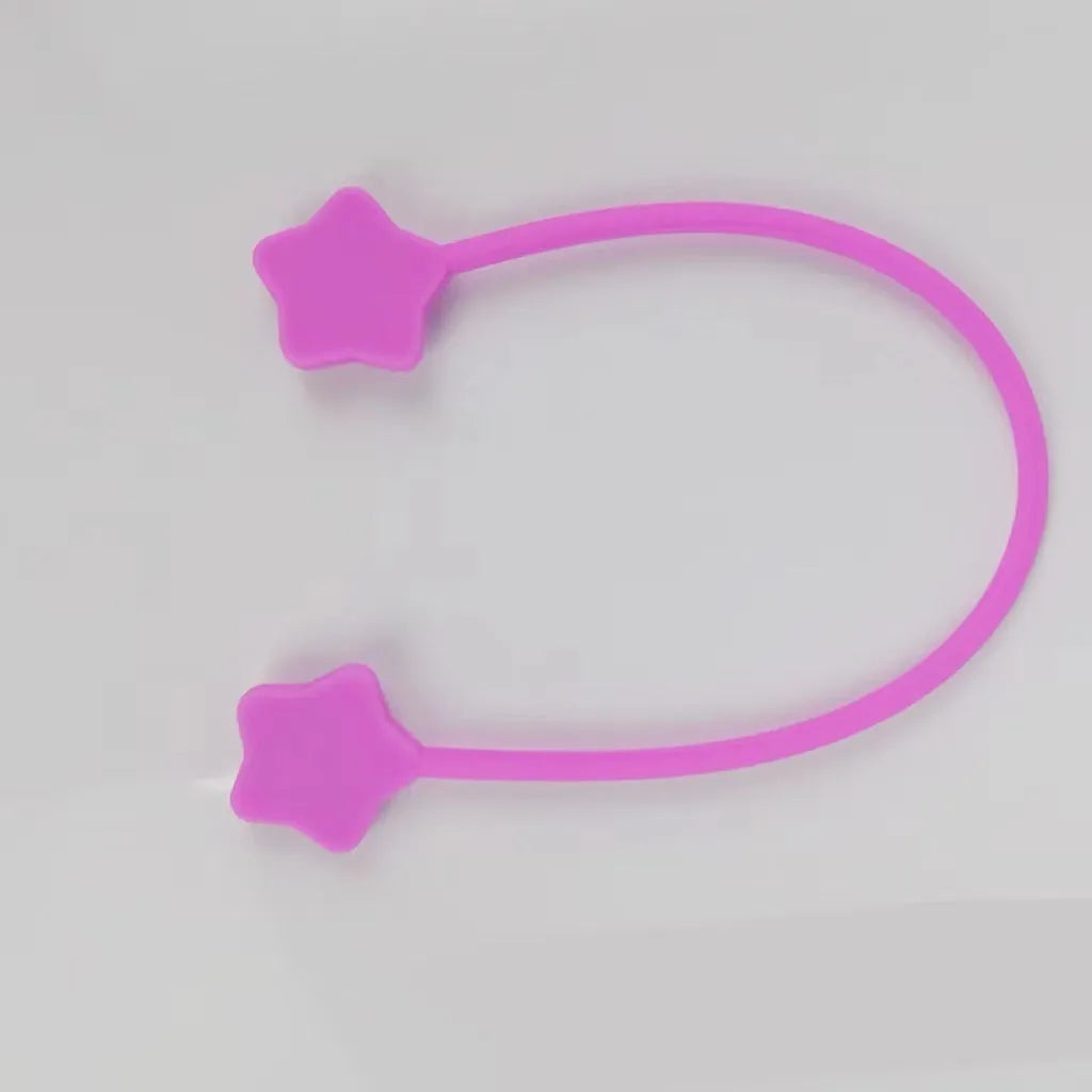 Small purple star-shaped silicone wire winder with magnet clip for organising phone or headphone cables.