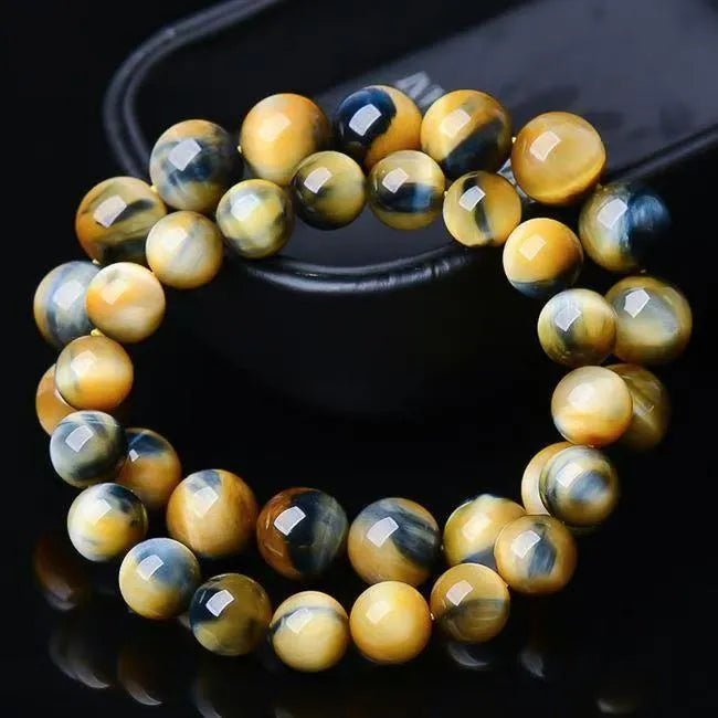 Close-up of a Fantasy Tiger Eye agate bracelet with round geometric beads on a wrist.