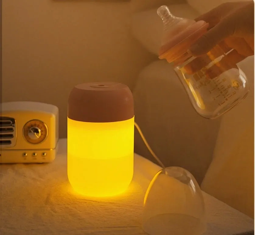 White cylindrical mini USB humidifier with aromatherapy function on a wooden surface.