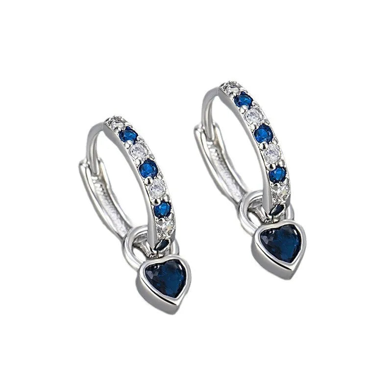 A pair of women's dangle earrings with a heart-shaped frame holding a coloured zircon stone.
