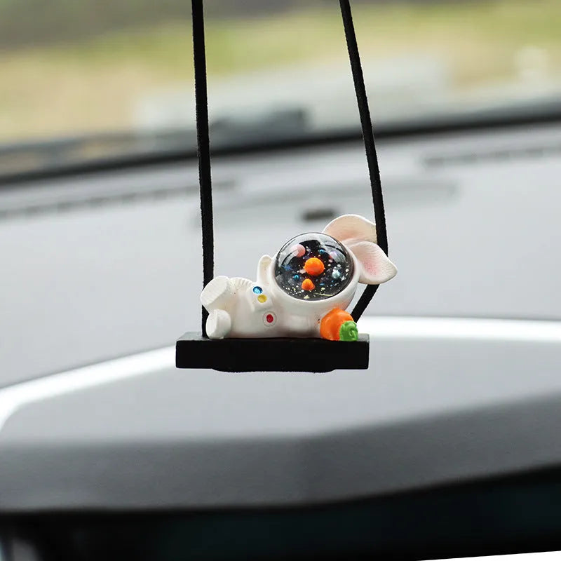 Colourful resin astronaut cartoon character car pendant hanging from a sun visor.