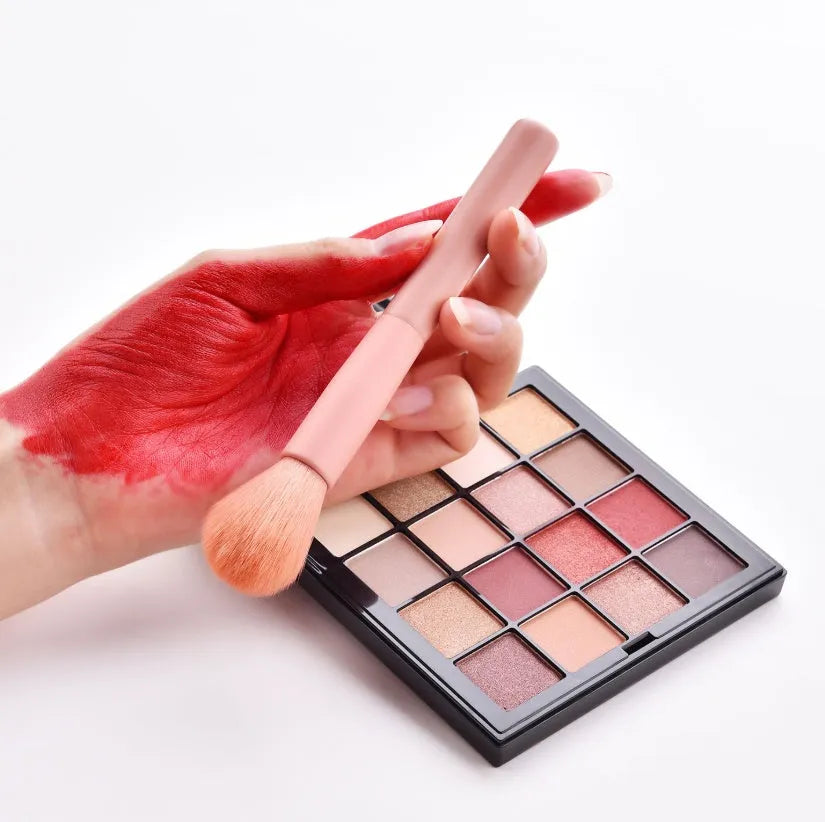 Ten professional makeup brushes with wooden handles in a pink box, including powder, foundation, and double-ended brushes.