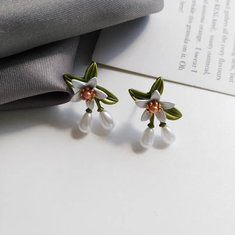 Alloy flower ear stud and matching clip-on earring pair with sterling silver needle camellia design.
