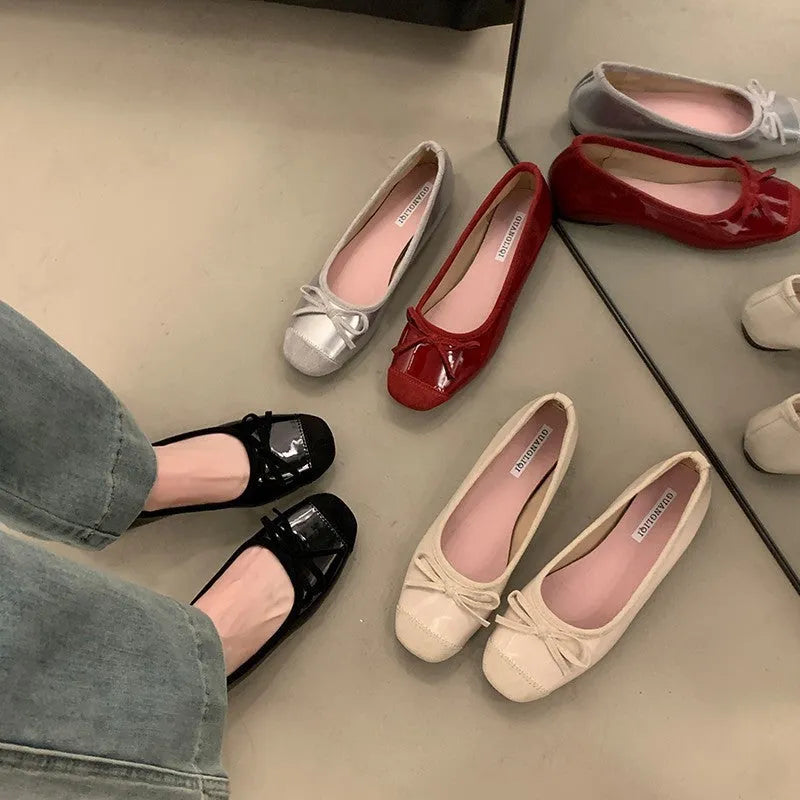 Wine red Mary Jane ballet flats with a bow and square toe on a rubber sole.