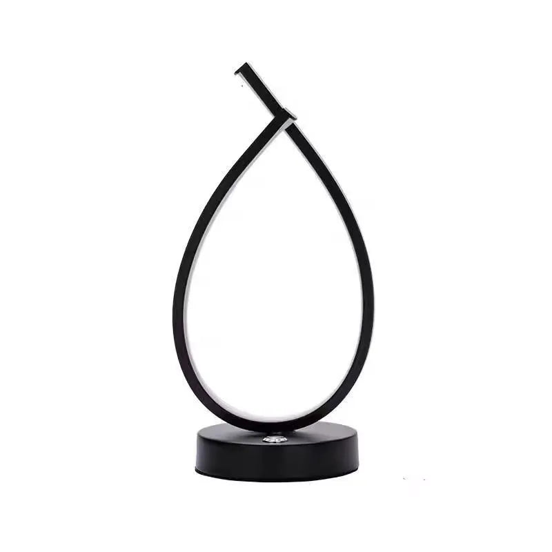 Black water drop shaped USB desk lamp with touch control on a wooden table