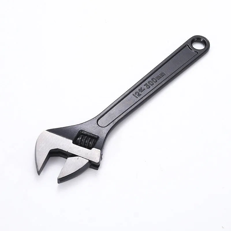 High carbon steel adjustable open-end spanner with black finish on a workbench.
