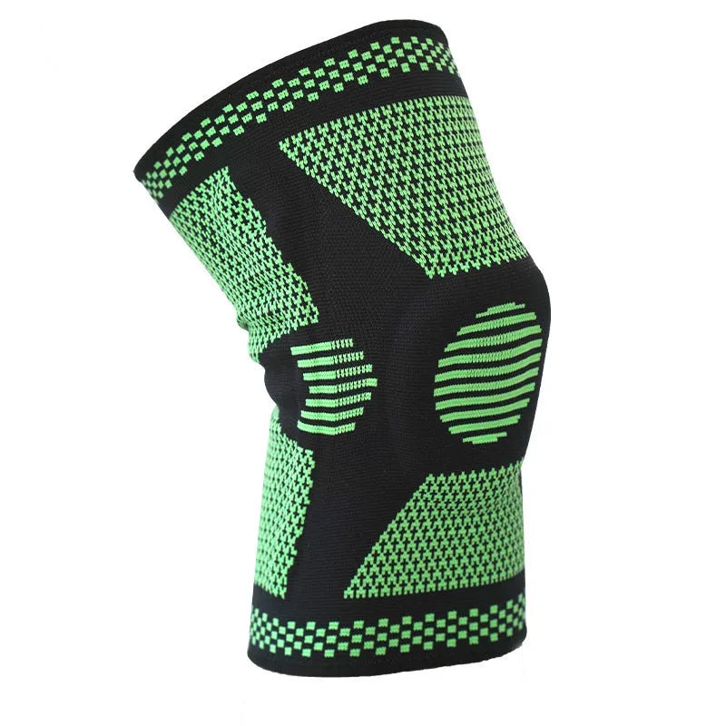 A green polyamide knee pad with a visible silicone spring and adjustable strap, laid flat.